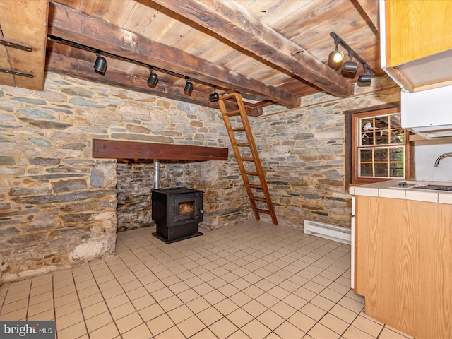 basement with wooden ceiling, a wood stove, and light tile floors