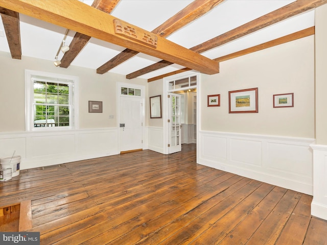 interior space with beam ceiling and dark hardwood / wood-style flooring