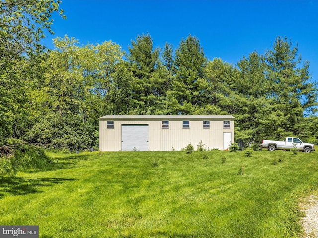 view of shed / structure featuring a garage and a lawn