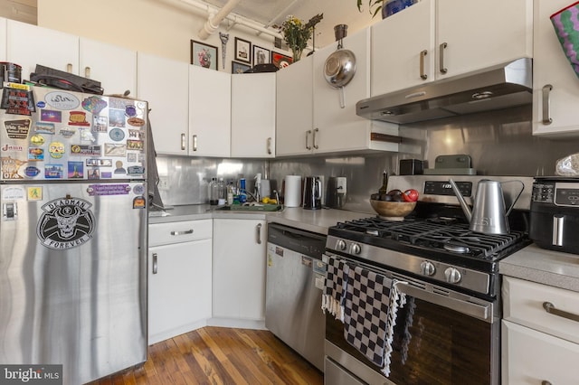 kitchen with white cabinets, dark hardwood / wood-style floors, backsplash, appliances with stainless steel finishes, and sink