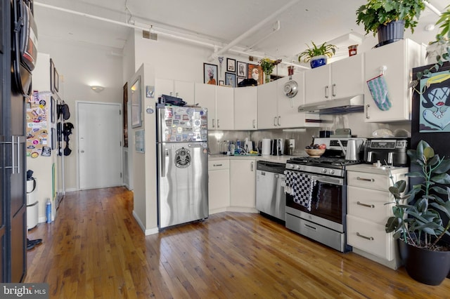 kitchen with dark hardwood / wood-style flooring, stainless steel appliances, and white cabinetry