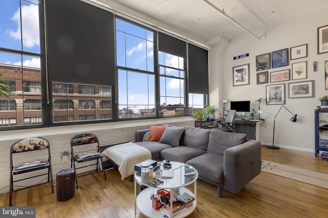 living room with plenty of natural light, hardwood / wood-style floors, and a towering ceiling