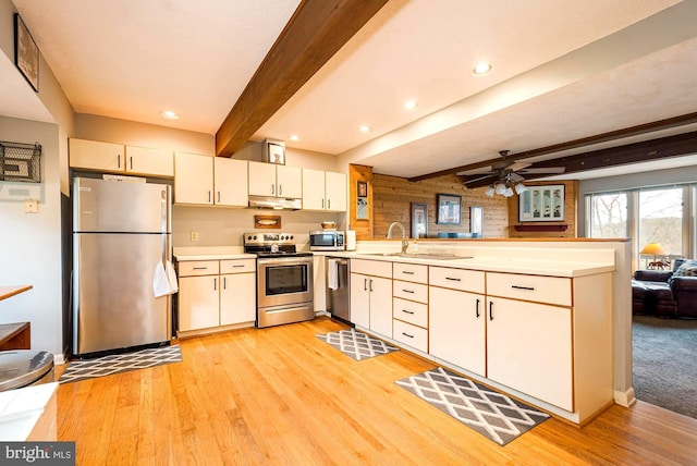 kitchen featuring appliances with stainless steel finishes, beam ceiling, ceiling fan, and light hardwood / wood-style floors