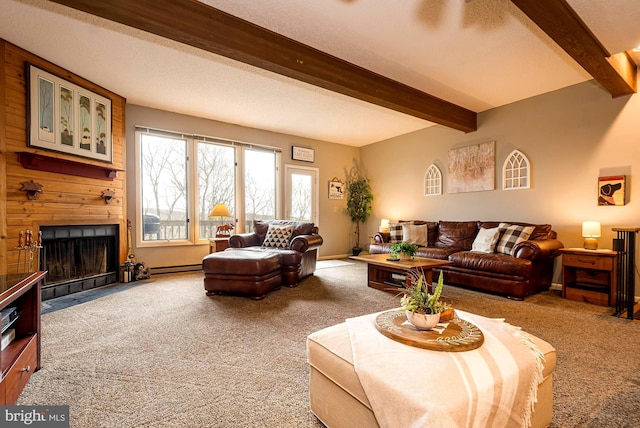 living room featuring carpet floors, beam ceiling, wooden walls, a baseboard radiator, and a fireplace