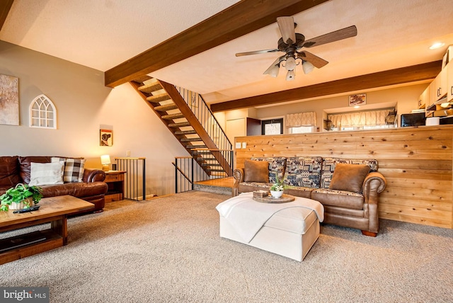 carpeted living room with beamed ceiling and ceiling fan