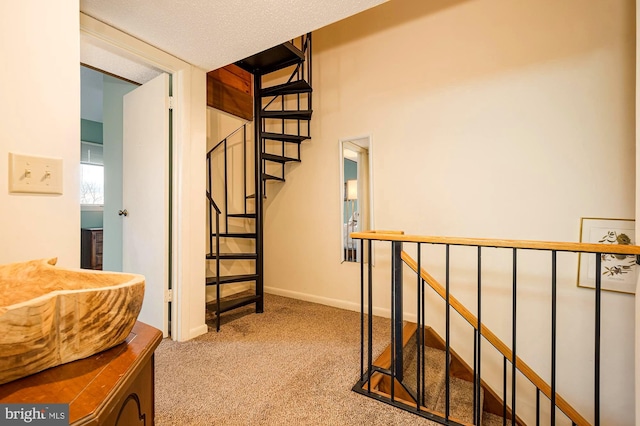 corridor featuring a textured ceiling and carpet flooring