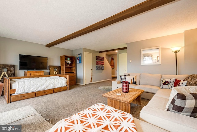 carpeted bedroom featuring beamed ceiling and a textured ceiling