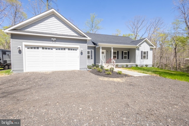 ranch-style home featuring covered porch and a garage