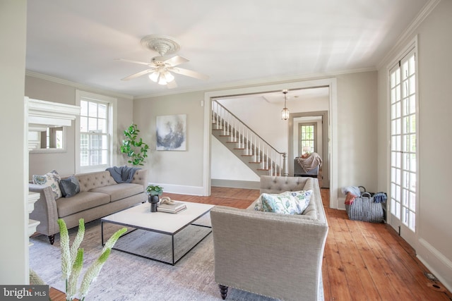living room featuring crown molding, wood-type flooring, and ceiling fan