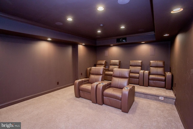 home theater with a raised ceiling, ornamental molding, and light colored carpet