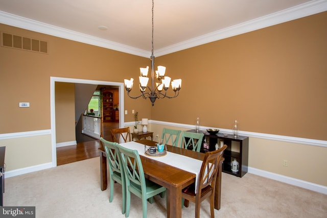 carpeted dining room with an inviting chandelier and crown molding