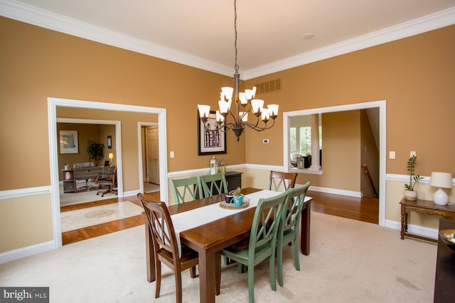 dining room with hardwood / wood-style floors, an inviting chandelier, and ornamental molding