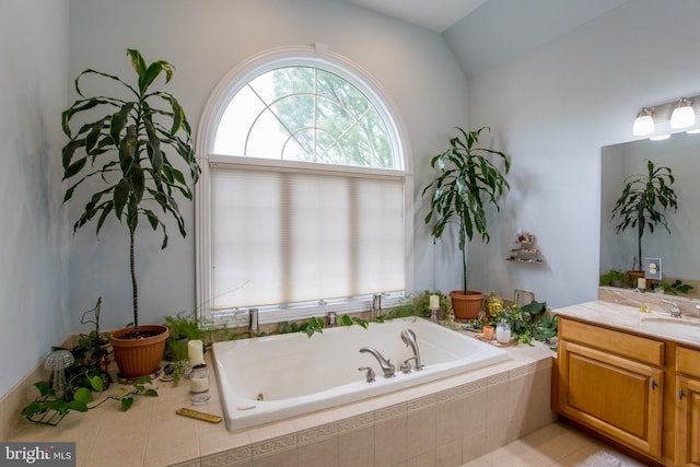 bathroom featuring vanity, tiled bath, tile patterned floors, and lofted ceiling