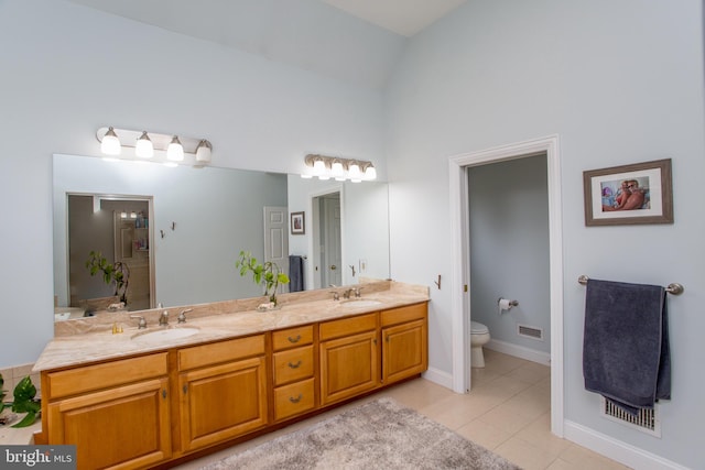 bathroom with dual vanity, tile patterned floors, toilet, and high vaulted ceiling