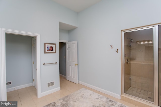 bathroom with tile patterned flooring and a tile shower