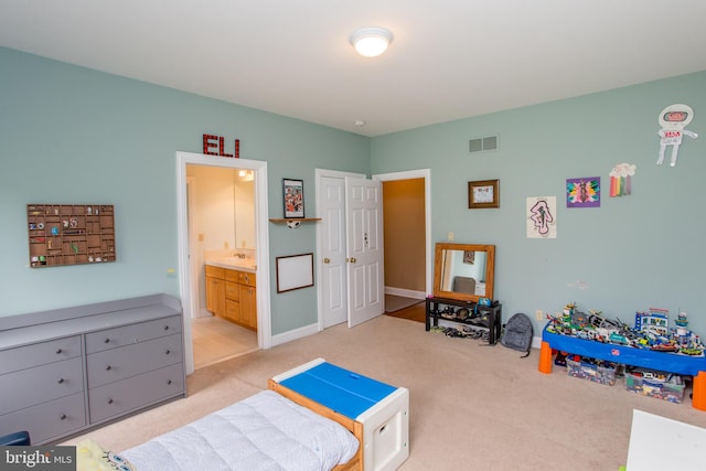 bedroom featuring connected bathroom and light colored carpet