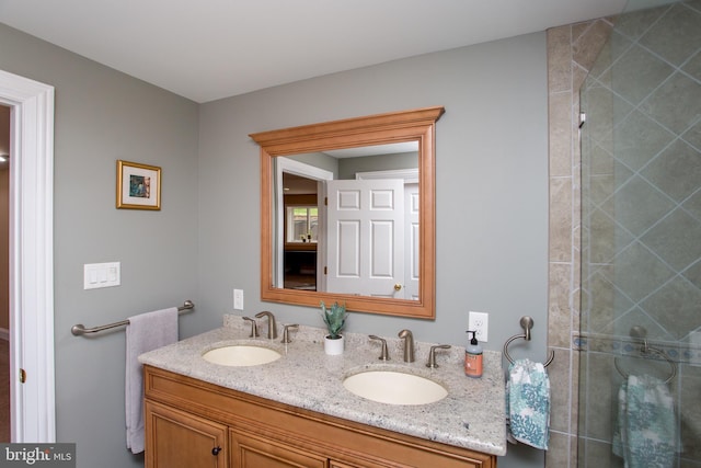 bathroom with dual vanity and a shower with door