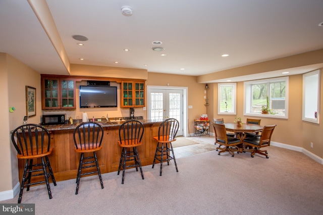 bar featuring light carpet and french doors