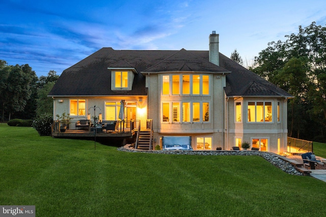 back of house with a deck and a lawn