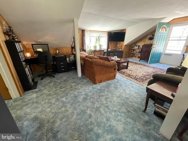 living room featuring wood walls, a textured ceiling, and carpet floors