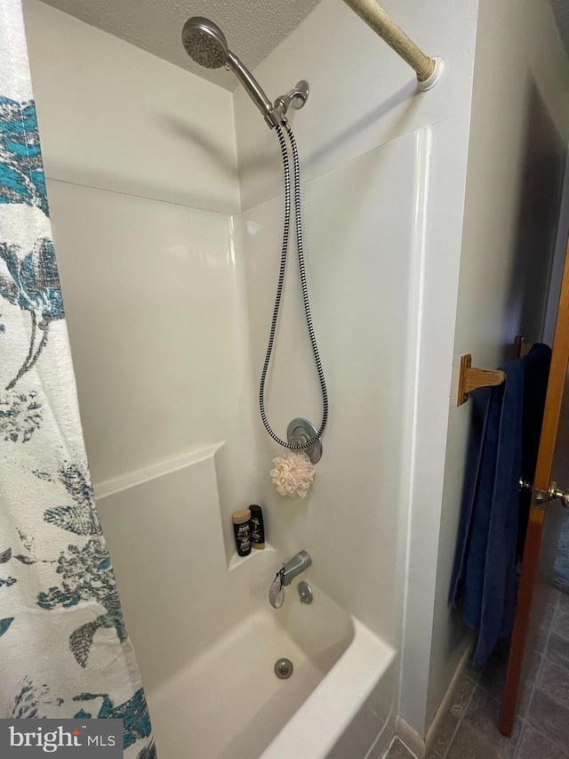 bathroom with tile flooring, shower / bath combination with curtain, and a textured ceiling