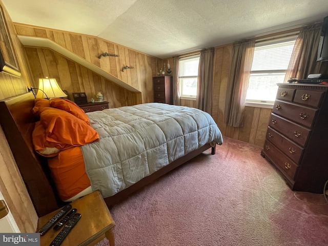 bedroom with vaulted ceiling, wood walls, carpet, and a textured ceiling