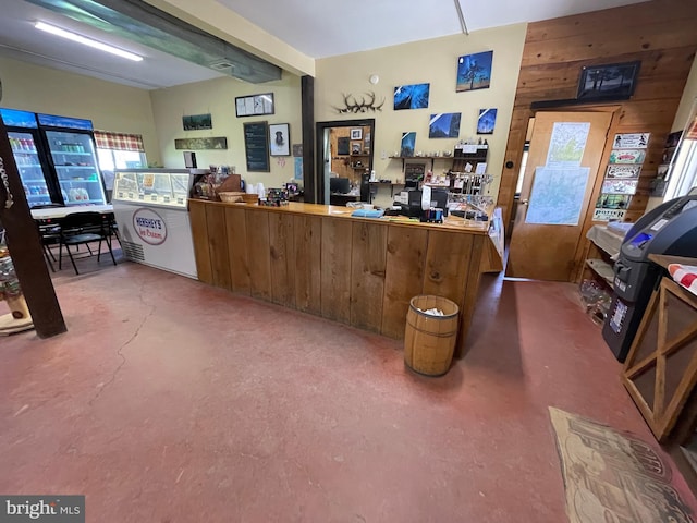 interior space with wood walls, washer / dryer, and concrete flooring