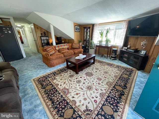 carpeted living room with lofted ceiling, a textured ceiling, and wooden walls