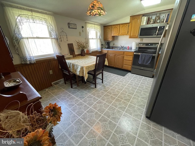 kitchen featuring sink, lofted ceiling, stainless steel appliances, and light tile flooring