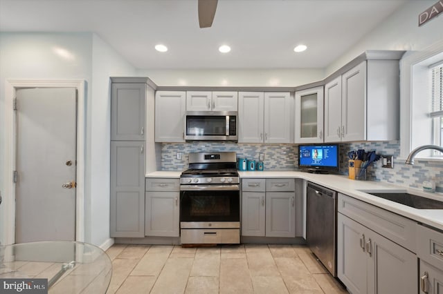 kitchen featuring tasteful backsplash, appliances with stainless steel finishes, sink, and light tile flooring