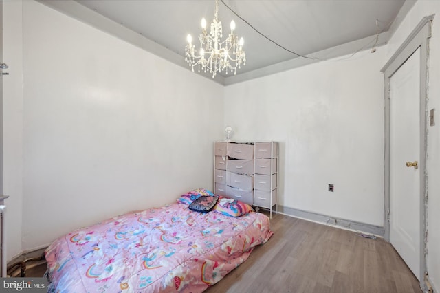 bedroom featuring wood-type flooring and an inviting chandelier