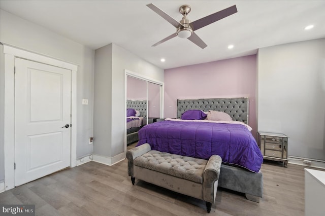 bedroom with hardwood / wood-style floors, a closet, and ceiling fan