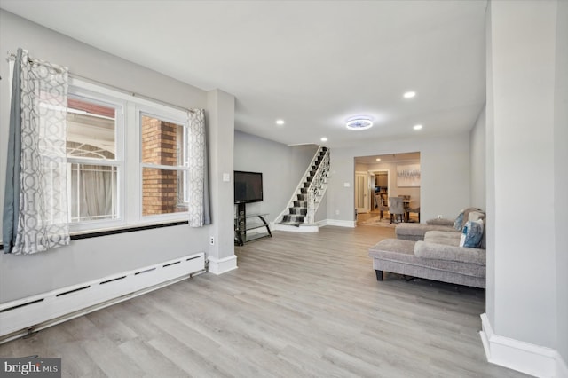 sitting room featuring light wood-type flooring and a baseboard heating unit