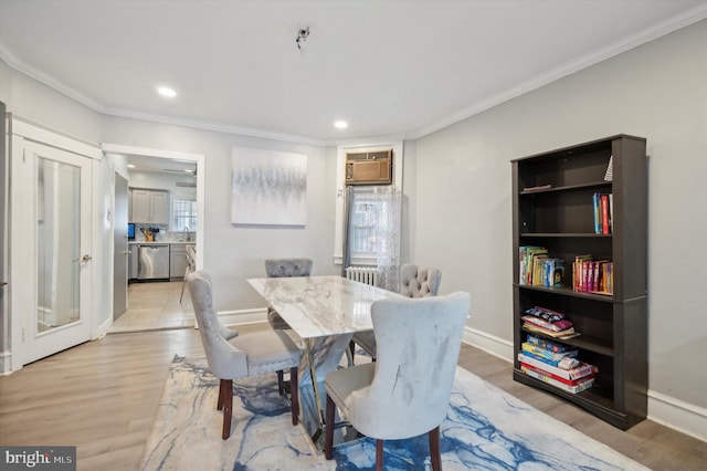 dining area with light hardwood / wood-style flooring, plenty of natural light, and ornamental molding