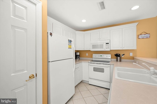 kitchen with white cabinets, white appliances, sink, and light tile floors