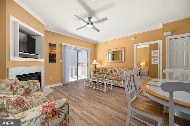 living room with a textured ceiling, light hardwood / wood-style floors, and a premium fireplace