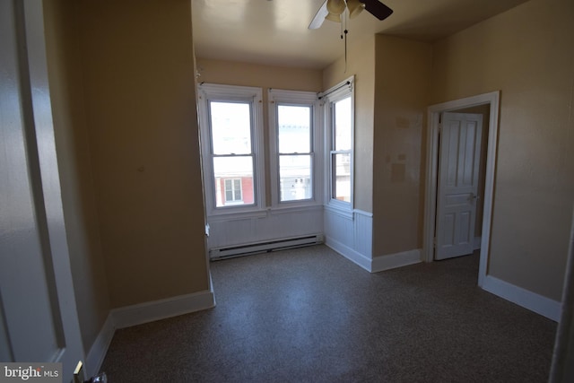 spare room with ceiling fan and a baseboard heating unit