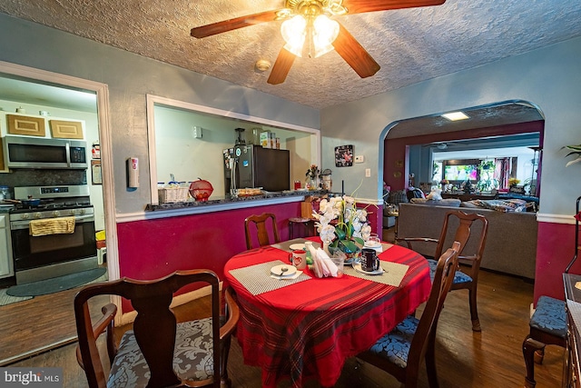 dining space featuring ceiling fan, hardwood / wood-style flooring, and a textured ceiling