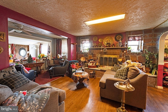 living room featuring a wealth of natural light, hardwood / wood-style flooring, and a brick fireplace