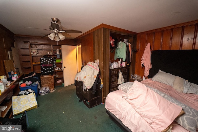 carpeted bedroom with wooden walls and ceiling fan