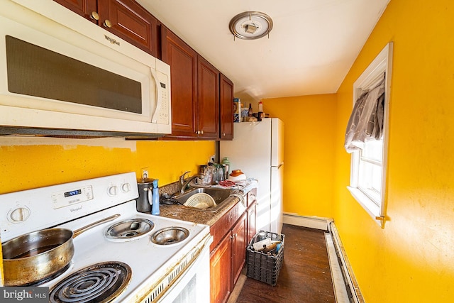 kitchen with sink, white appliances, baseboard heating, and dark wood-type flooring