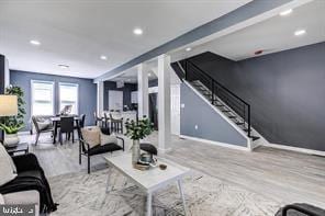 living room with beam ceiling and light wood-type flooring