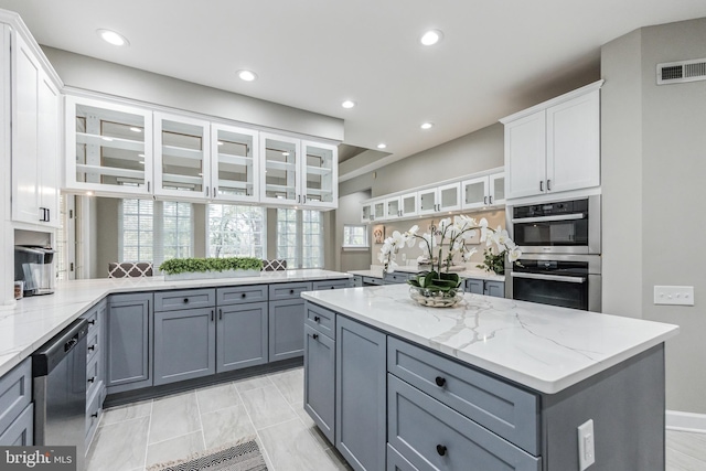 kitchen with gray cabinets, stainless steel appliances, and white cabinetry