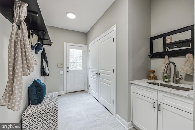 mudroom featuring sink and light tile floors