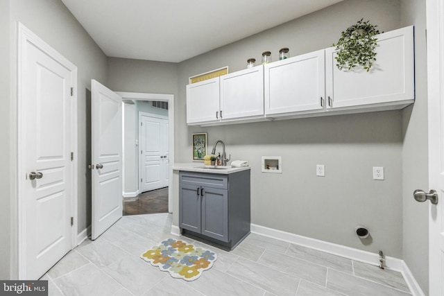 laundry room featuring cabinets, light tile floors, sink, and hookup for a washing machine