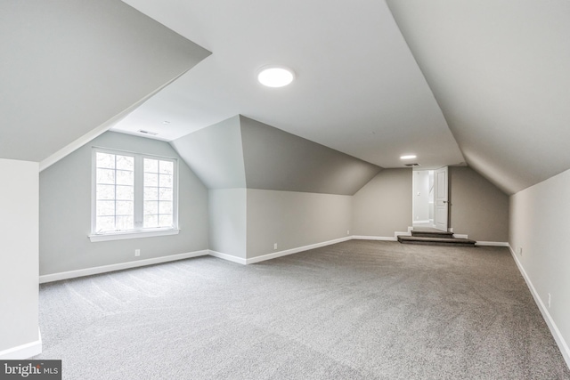 bonus room with vaulted ceiling and carpet flooring