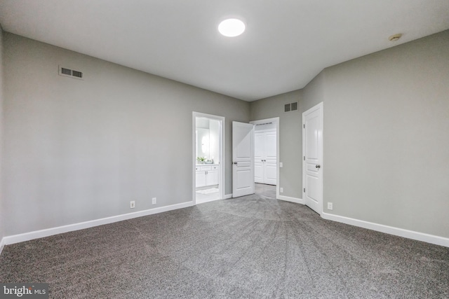 unfurnished bedroom featuring carpet and connected bathroom