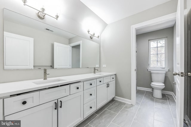 bathroom with toilet, tile floors, and dual vanity