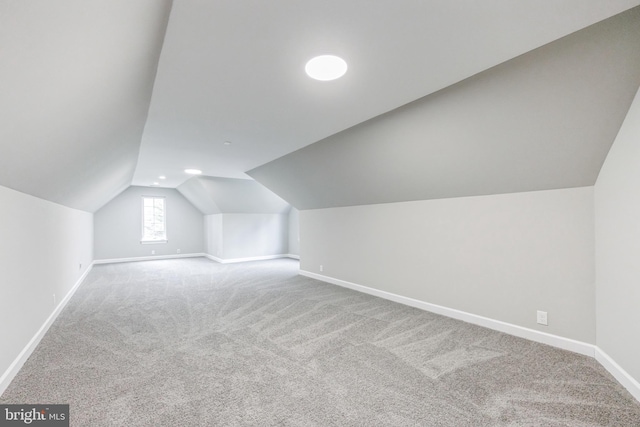 additional living space with vaulted ceiling and carpet floors