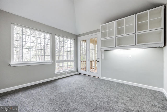 carpeted empty room with french doors and lofted ceiling